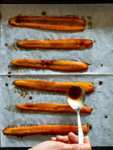 echando marinada a tiras de zanahoria.