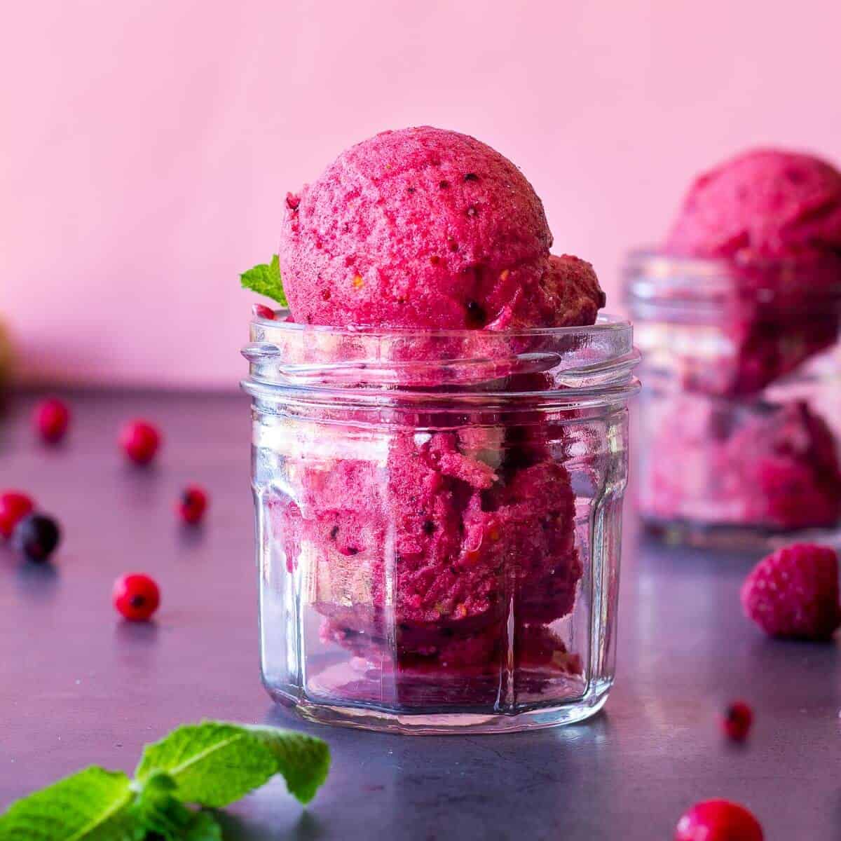 Helado cremoso de plátano y frutos rojos en un vaso frío.