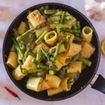 pasta con espárragos en una sartén.