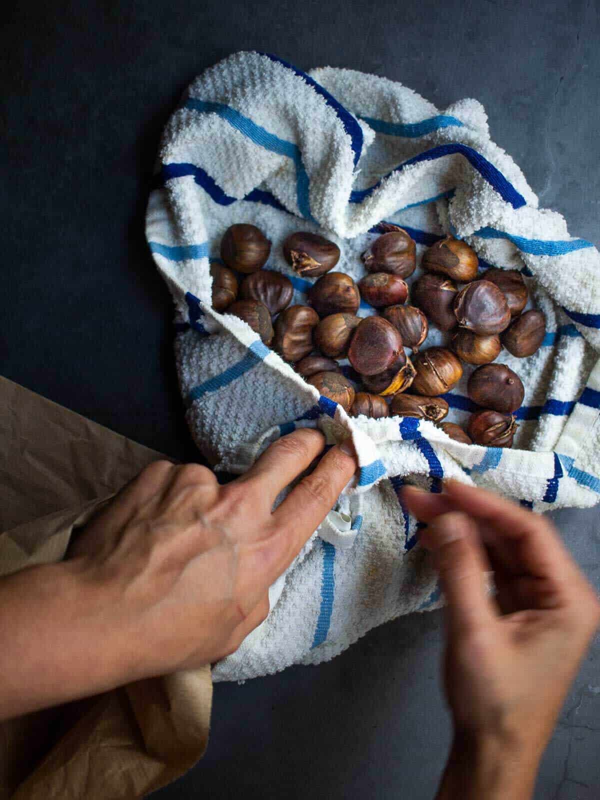 secando castañas escurridas con un trapo de cocina.