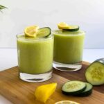 dos vasos servidos con batido de piña y pepino.
