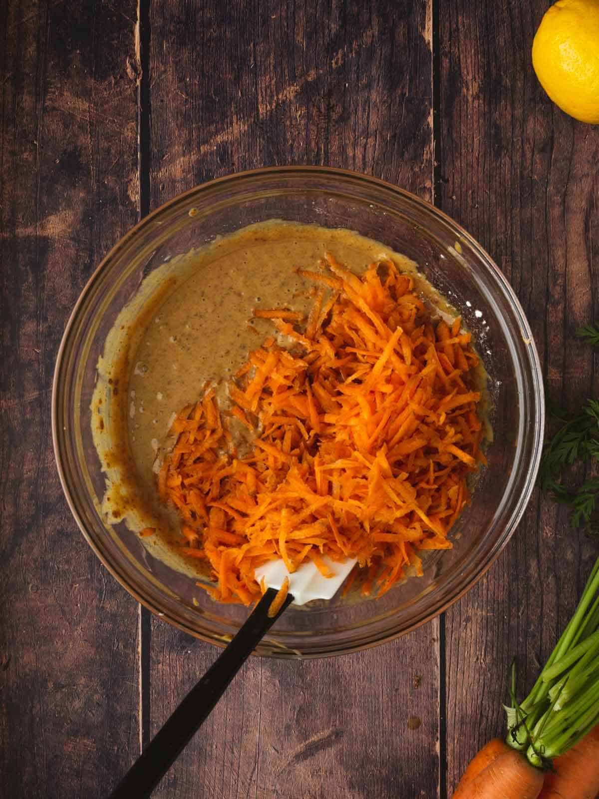 bowl con mezcla de ingredientes húmedos y zanahoria rayada.