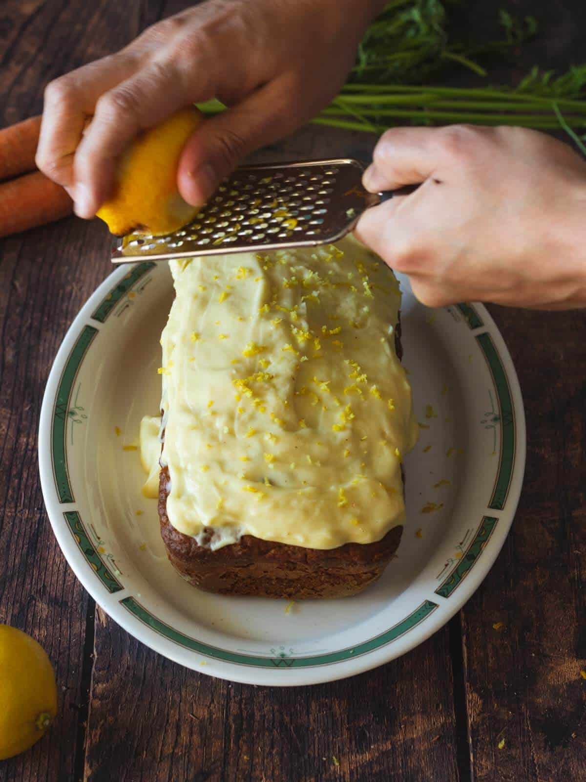 rayando cáscara de limón sobre el glaseado.