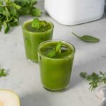 Primer plano de un zumo verde natural con menta y hielo, perfecto para la digestión.