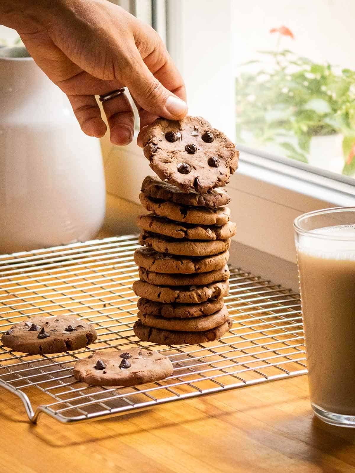torre de galletas proteicas de chocolate con un vaso de leche vegana.