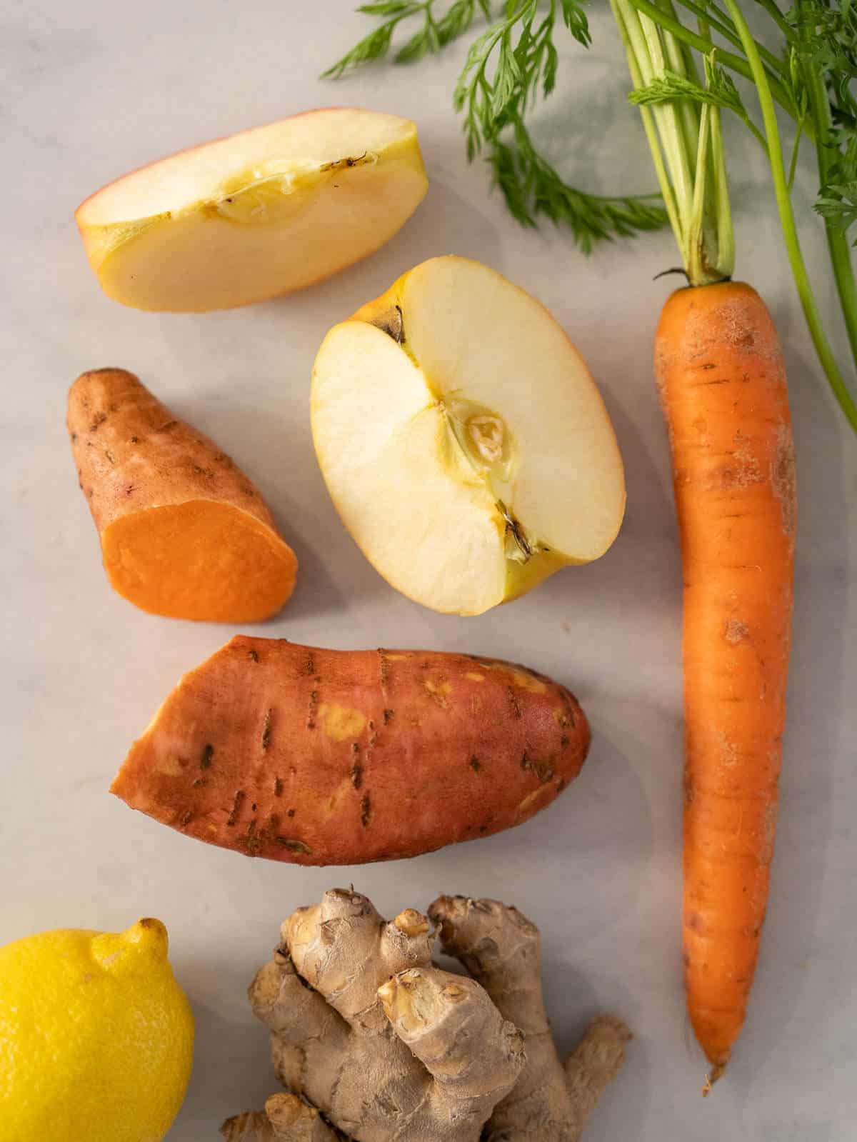 ingredientes preparados para hacer zumo de zanahoria, manzana y boniato.