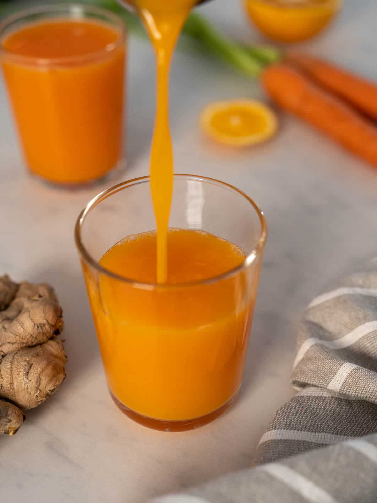 sirviendo zumo de zanahoria y naranja mas jengibre.