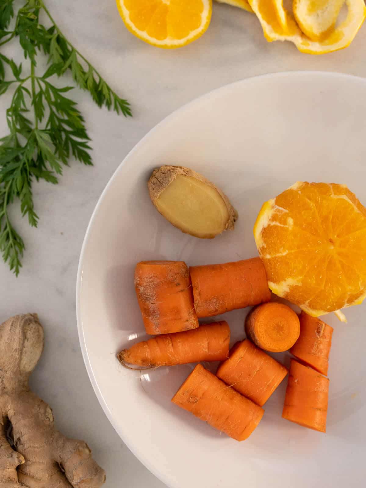 ingredientes para hacer zumo de zanahoria, naranja y jengibre.