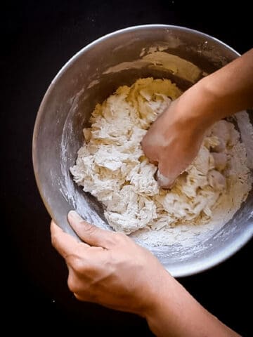 amasando los ingredientes de los bollos de pan.