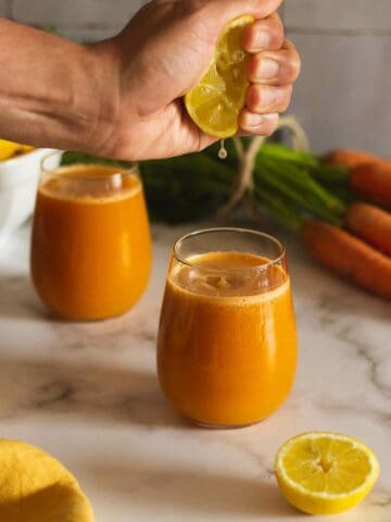 exprimiendo limón sobre jugo antiinflamatorio.