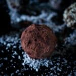 Primer plano de una trufa vegana de chocolate espolvoreada con cacao.