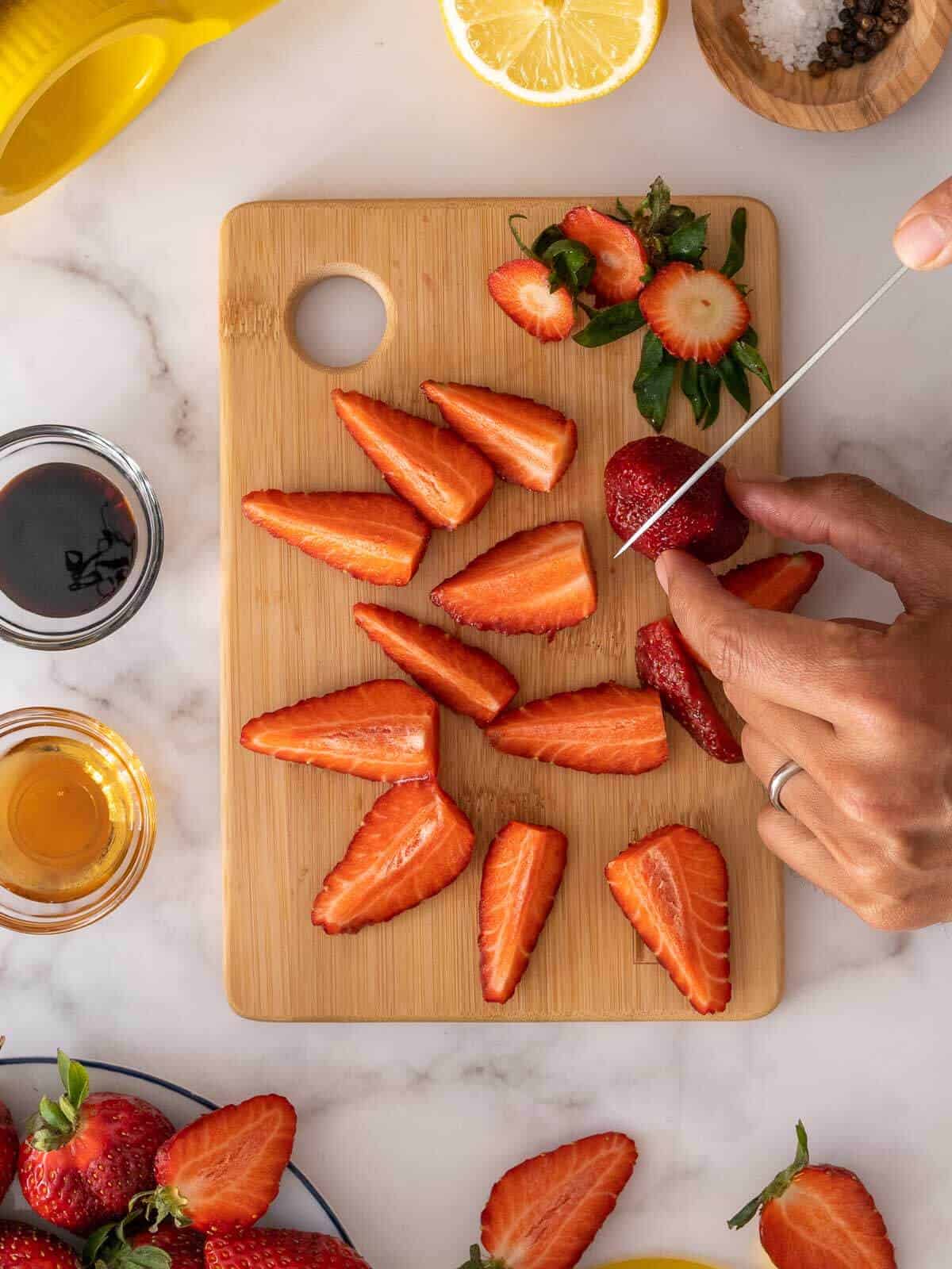 cortando las fresas frescas en cuartos.