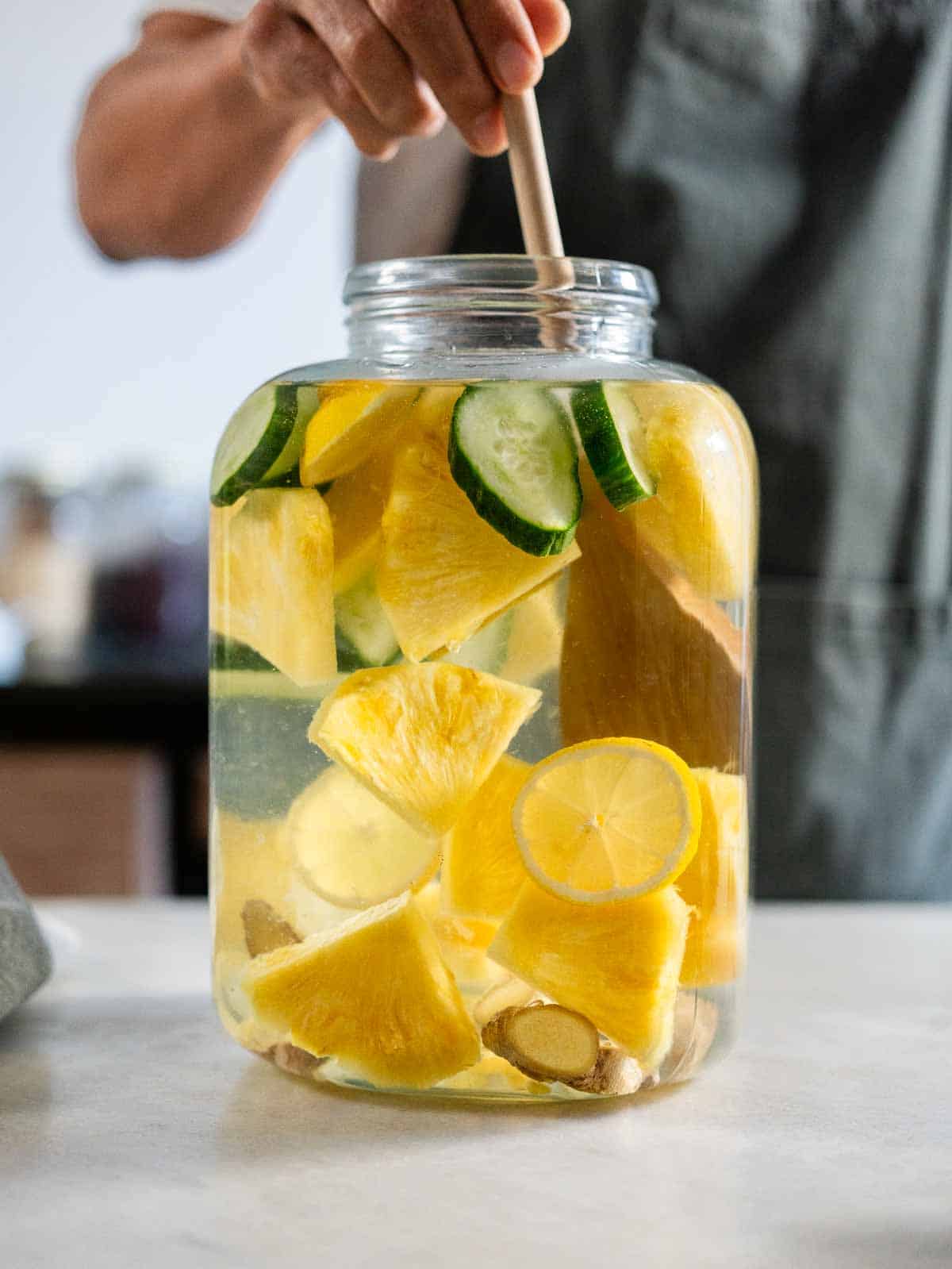 mezclar el agua infusionada con todos los ingredientes en una jarra utilizando una cuchara de madera.