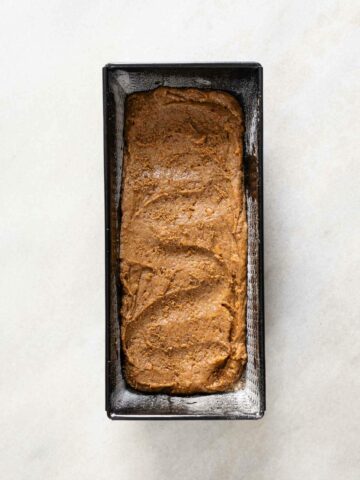 transfiere la masa a un molde para pan y empareja la superficie uniformemente con una espátula.