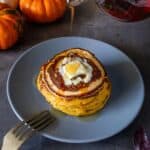 vertiendo jarabe de arce sobre pancakes de calabaza veganos.