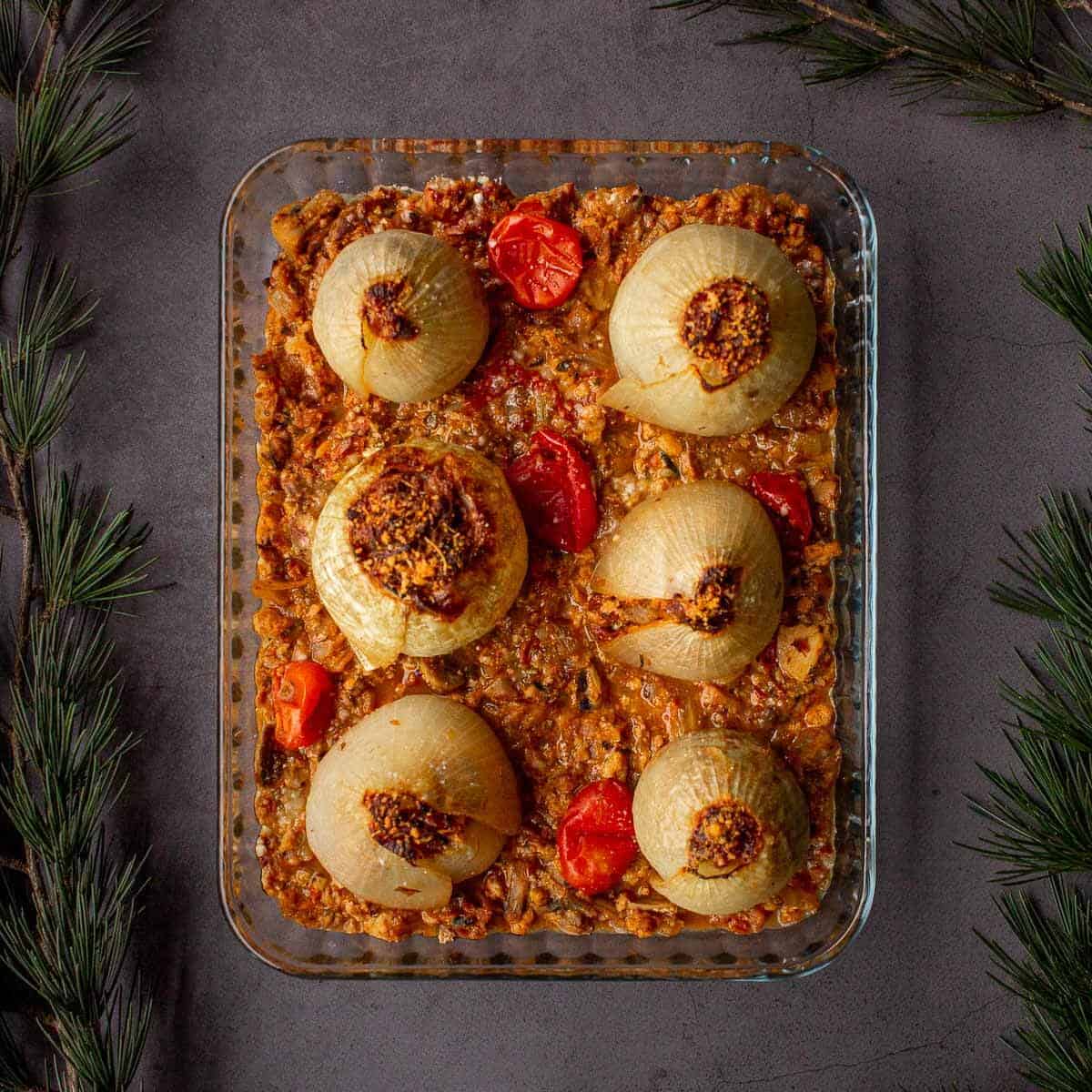 fuente de vidrio con cebollas rellenas al horno.