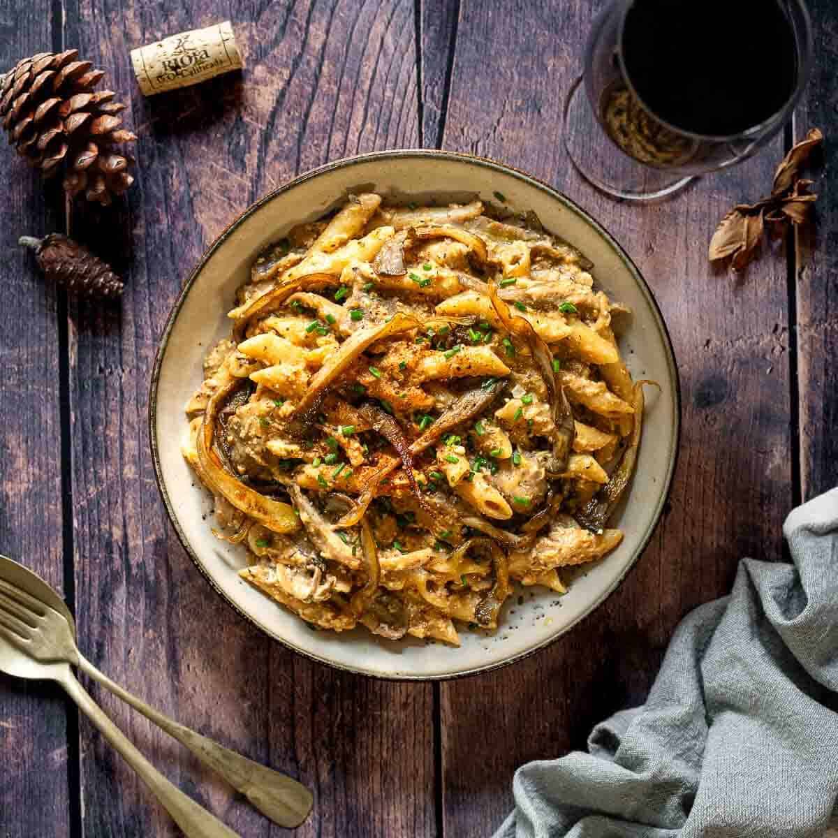 stroganoff vegano en una olla servido junto a una copa de vino.