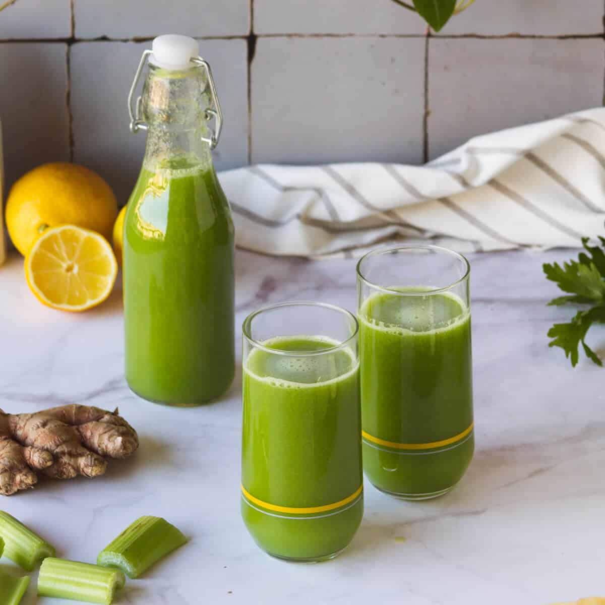 Una botella pequeña y dos vasos de jugo de apio.