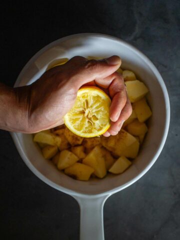 exprimir limón sobre la olla con las manzanas cortadas en cubos.
