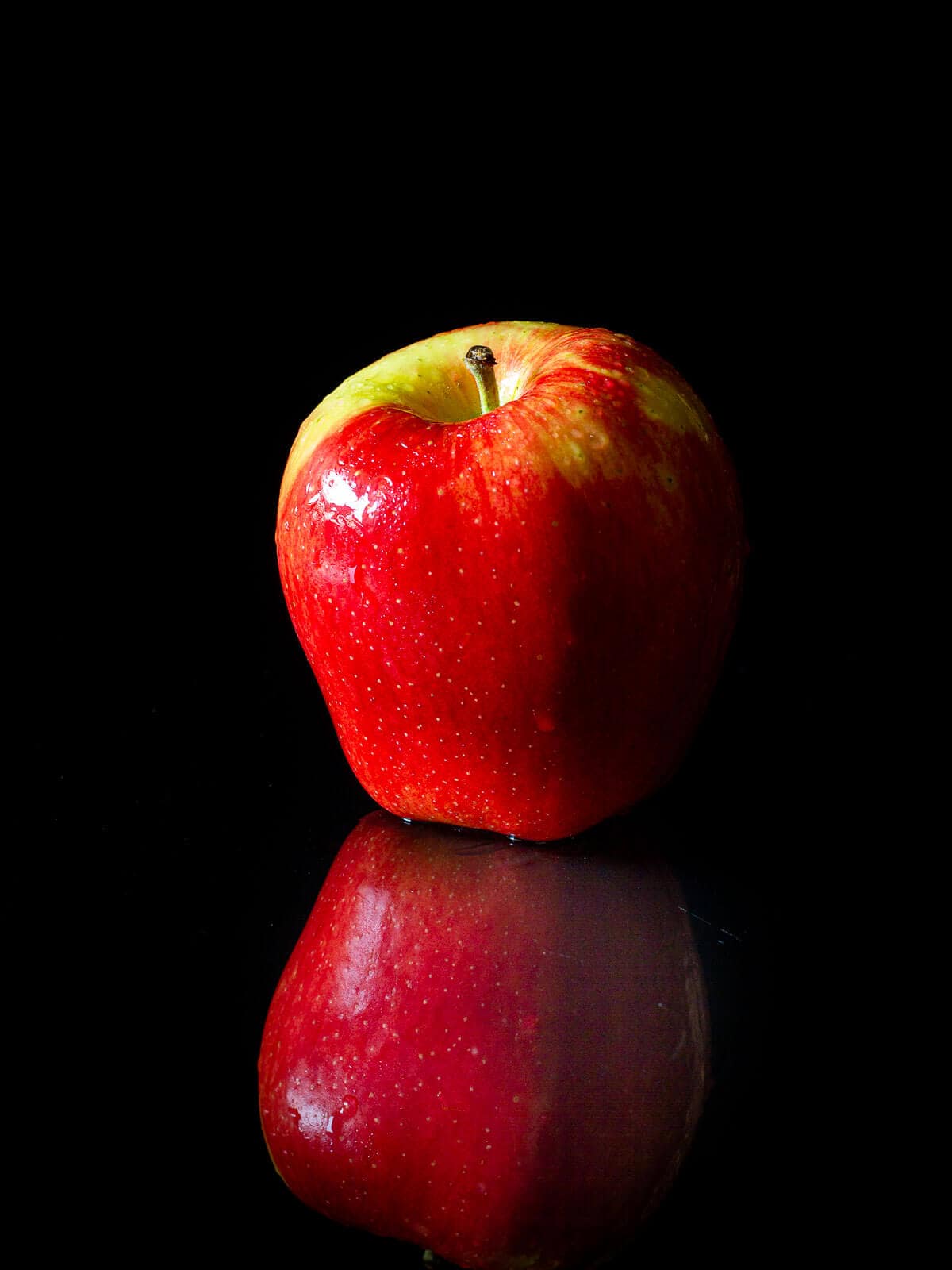 manzana roja gala sobre fondo negro.