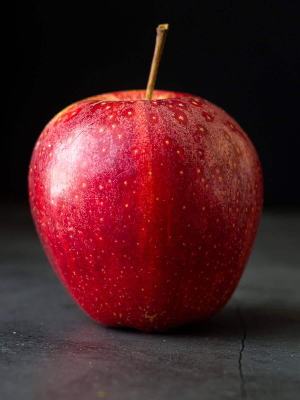 manzana roja sobre fondo negro.