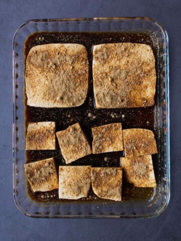 marinar el tofu extra firme con una salsa de ajo en polvo y salsa de soya.