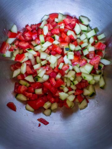 colocar el tomate y el pepino en un bowl cortados en cubos y con sal para eliminar el exceso de agua.