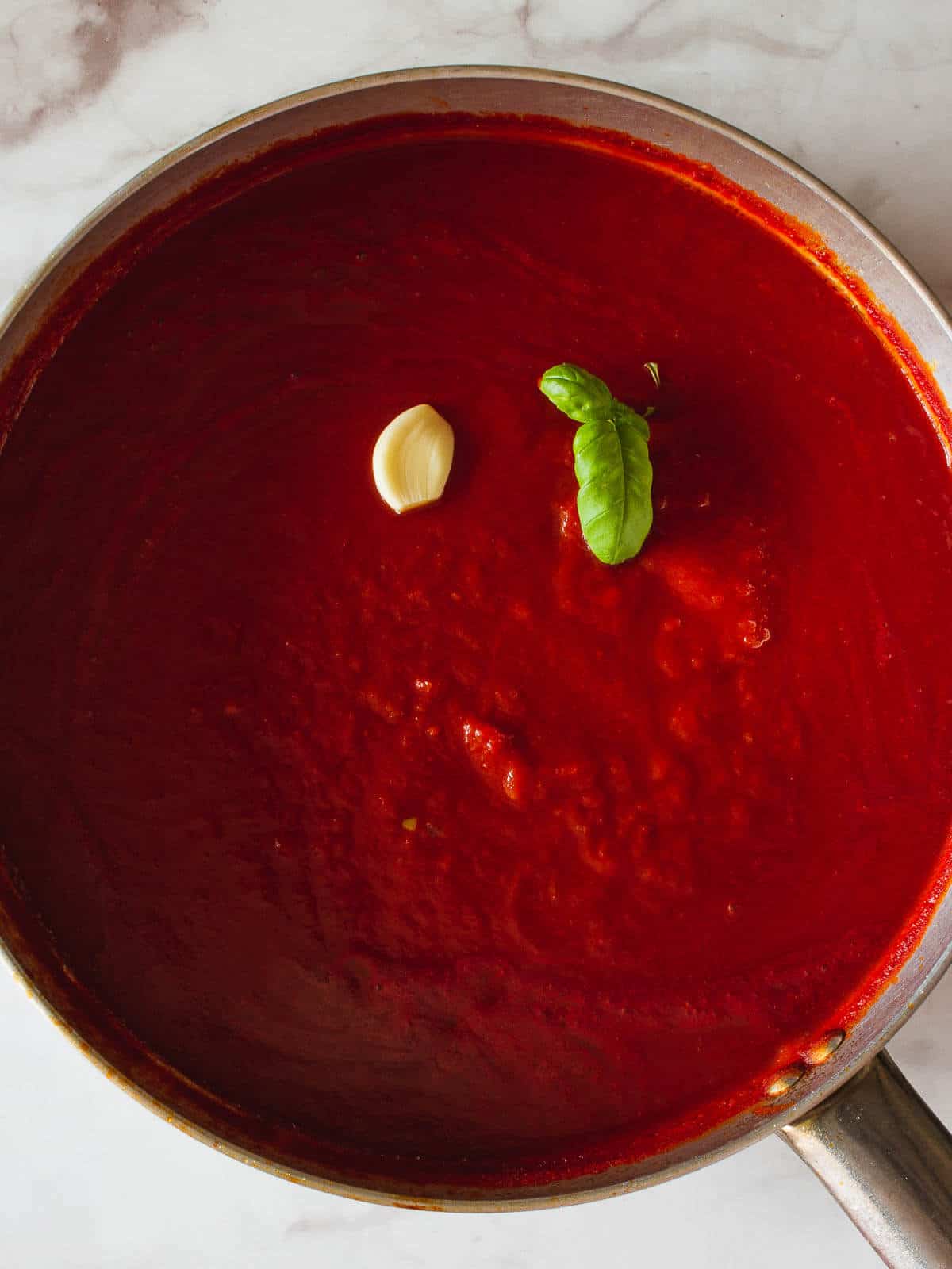 salsa de tomate con ajo y albahaca en una cazuela.