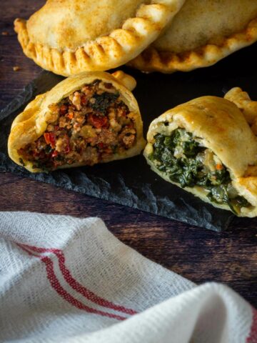 dos mitades de empanadas con rellenos diferentess.