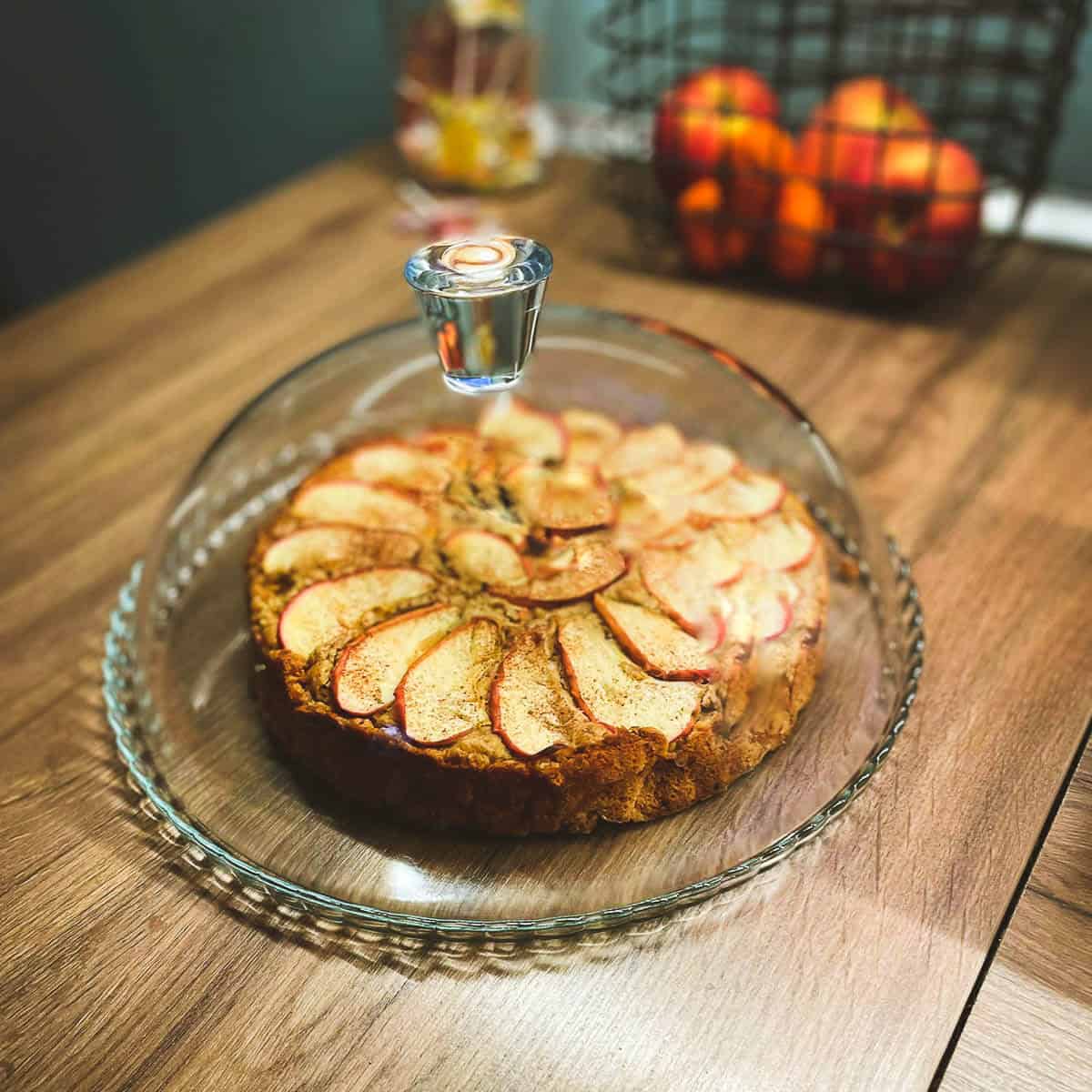 tarta de manzana horneada cubierta por una campana de vidrio.