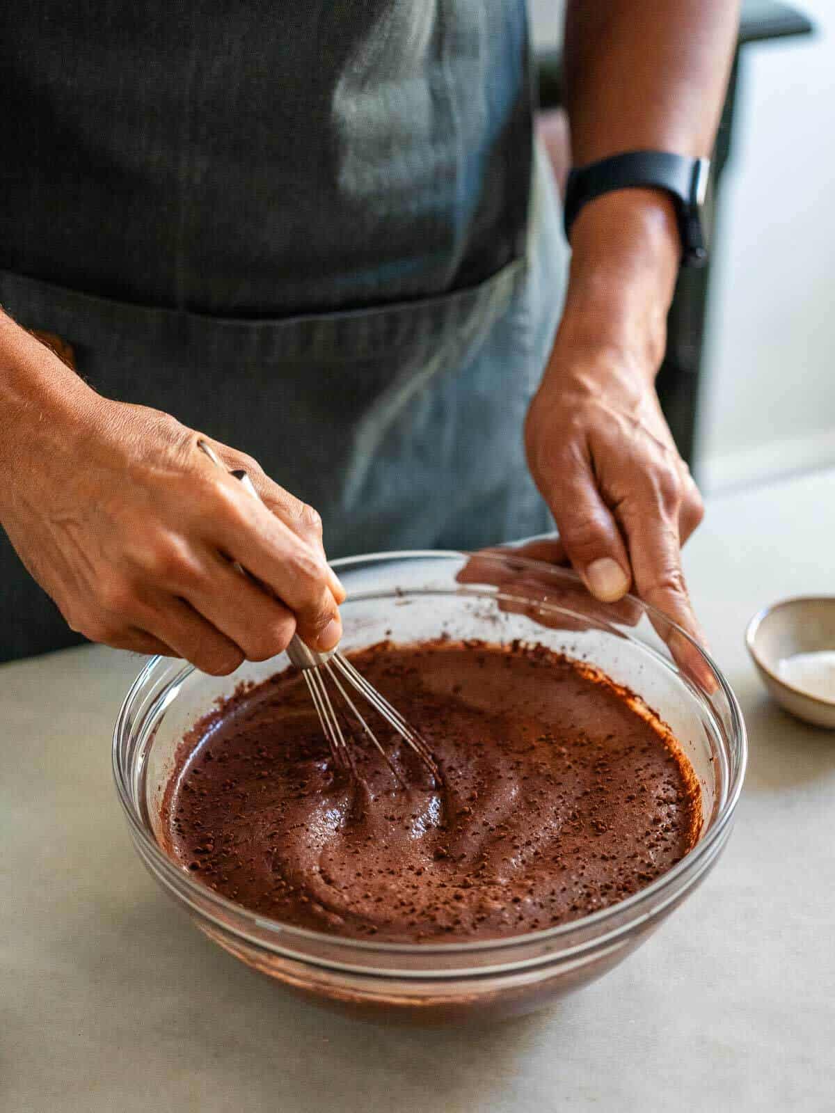 Mezclando cacao en polvo en la mezcla de buttermilk vegano y harina de lino, usando un batidor.