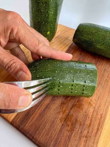 insertando tenedor en las afueras de los zucchini.
