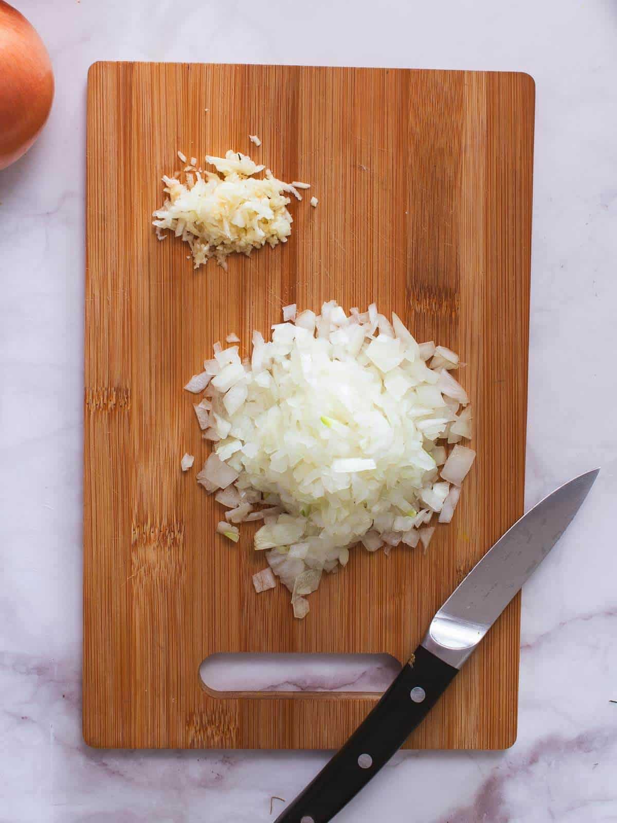 Prepara las cebollas y el ajo - pela y pica tus cebollas. Pica finamente los dientes de ajo.