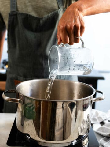 vierte agua en la olla para cocer a fuego lento los ingredientes.