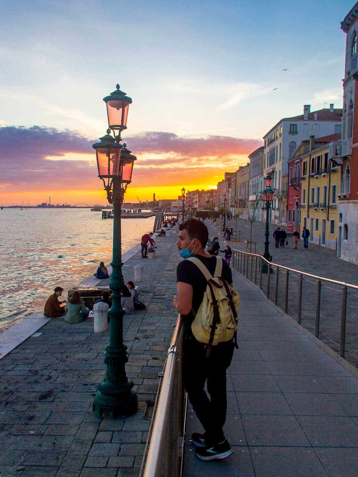 Atardecer en Venecia - Persona caminando por el paseo marítimo al atardecer en Venecia.