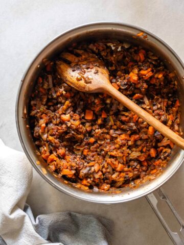 La mezcla del relleno cocinándose en una olla, mostrando los vegetales finamente picados y lentejas cociéndose juntos.