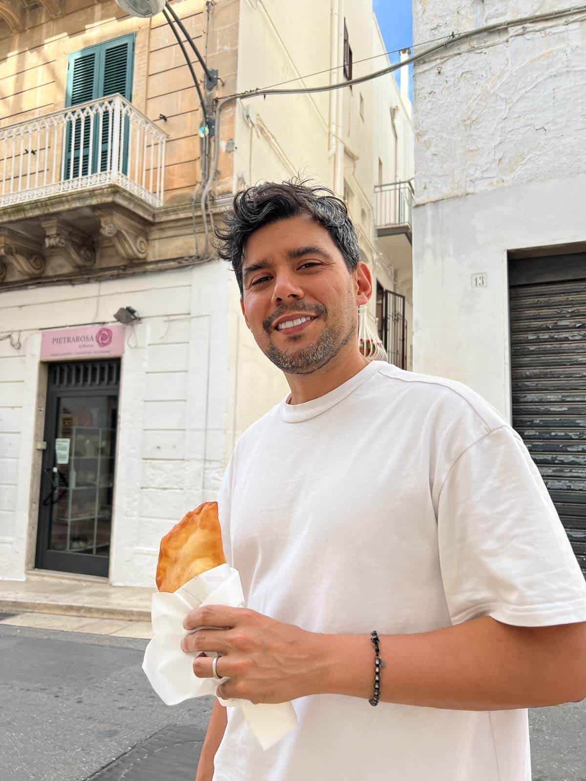 Persona sosteniendo un panzerotto en Ostuni.