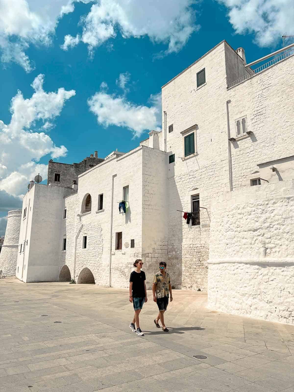 Personas caminando por una calle empedrada en Ostuni