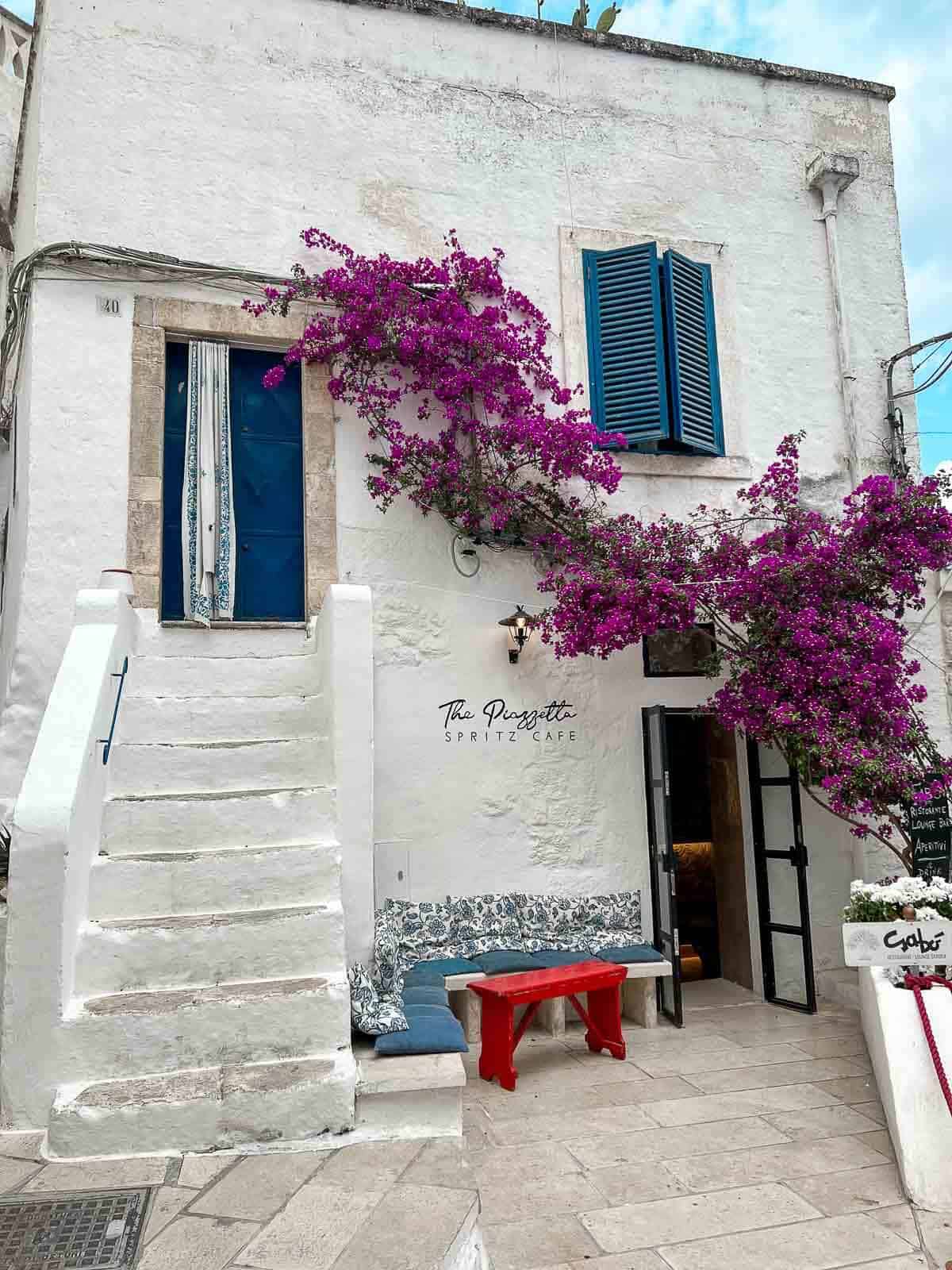 Escalera blanca adornada con flores en Ostuni.