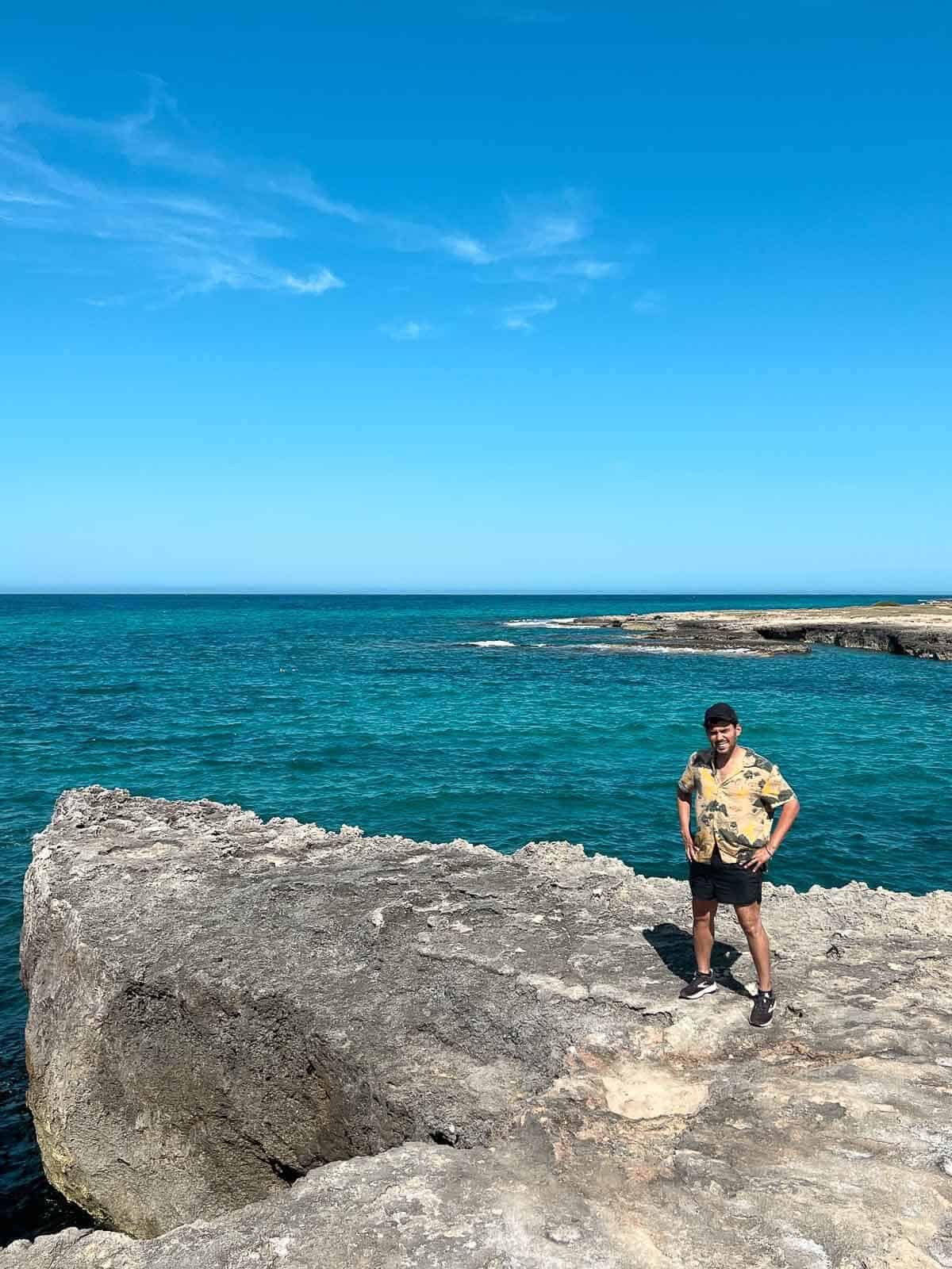 Persona posando en la costa rocosa en Torre Guachetto near Ostuni.