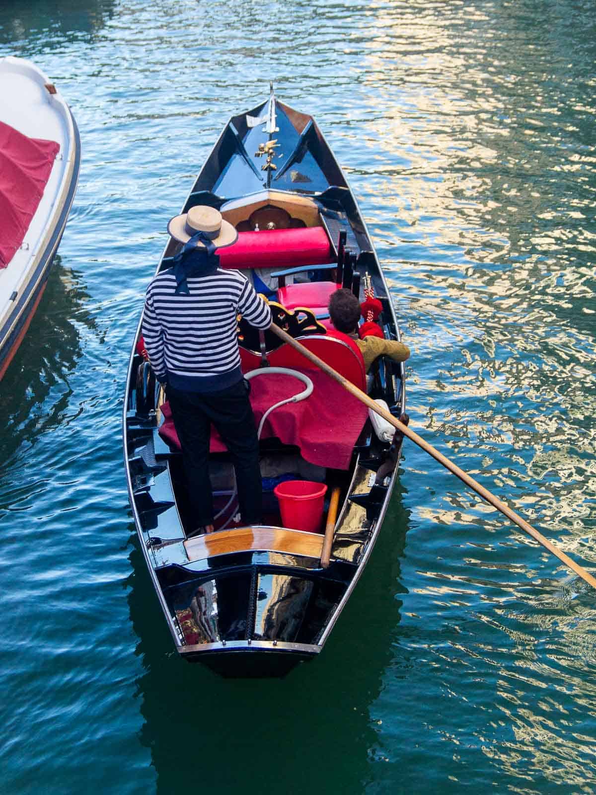 Gondoleros en sus góndolas en Venecia - Gondoleros en sus góndolas listos para navegar por el canal.