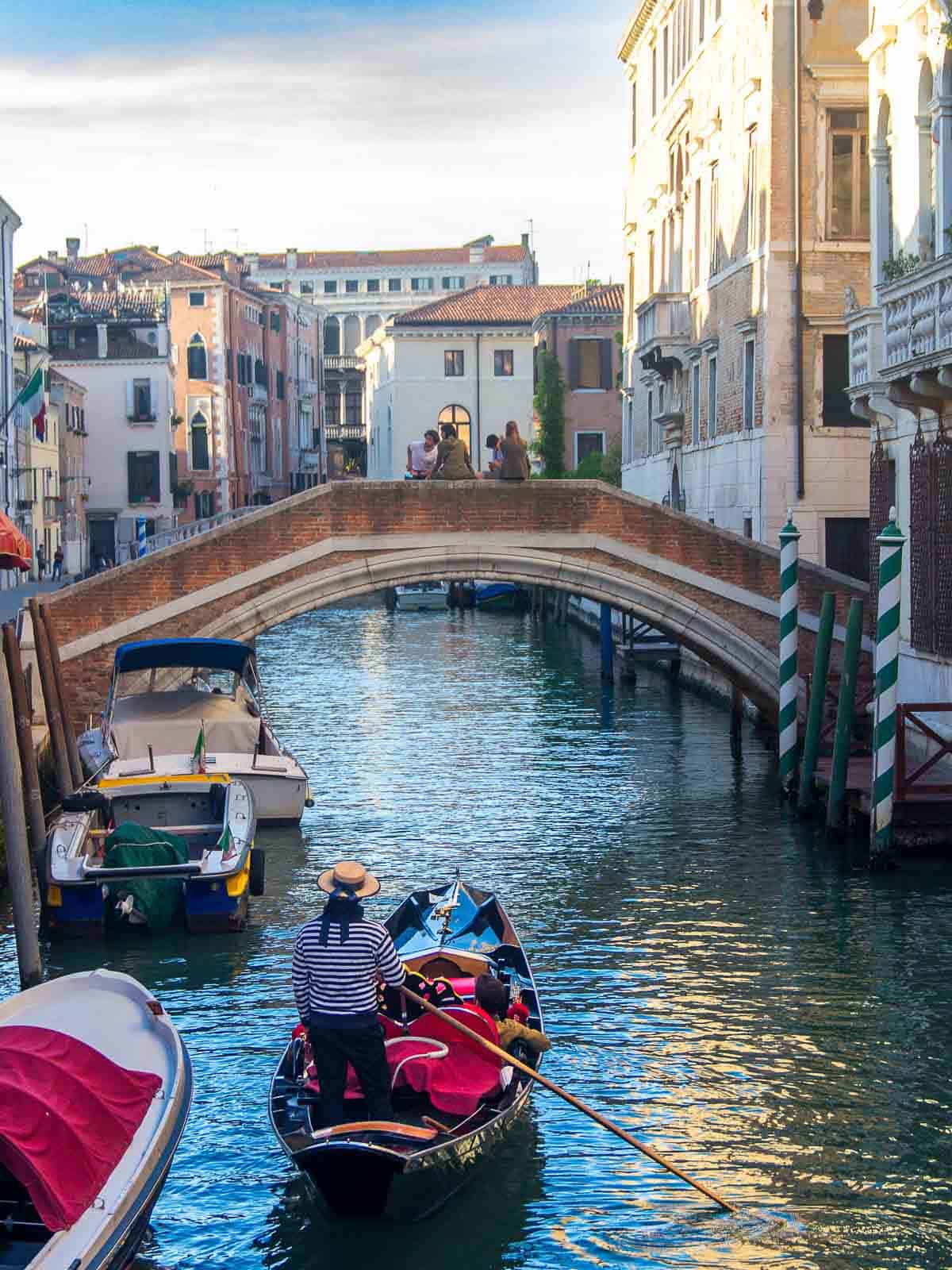 Gondoleros en sus góndolas en Venecia - Gondoleros en sus góndolas listos para navegar por el canal.