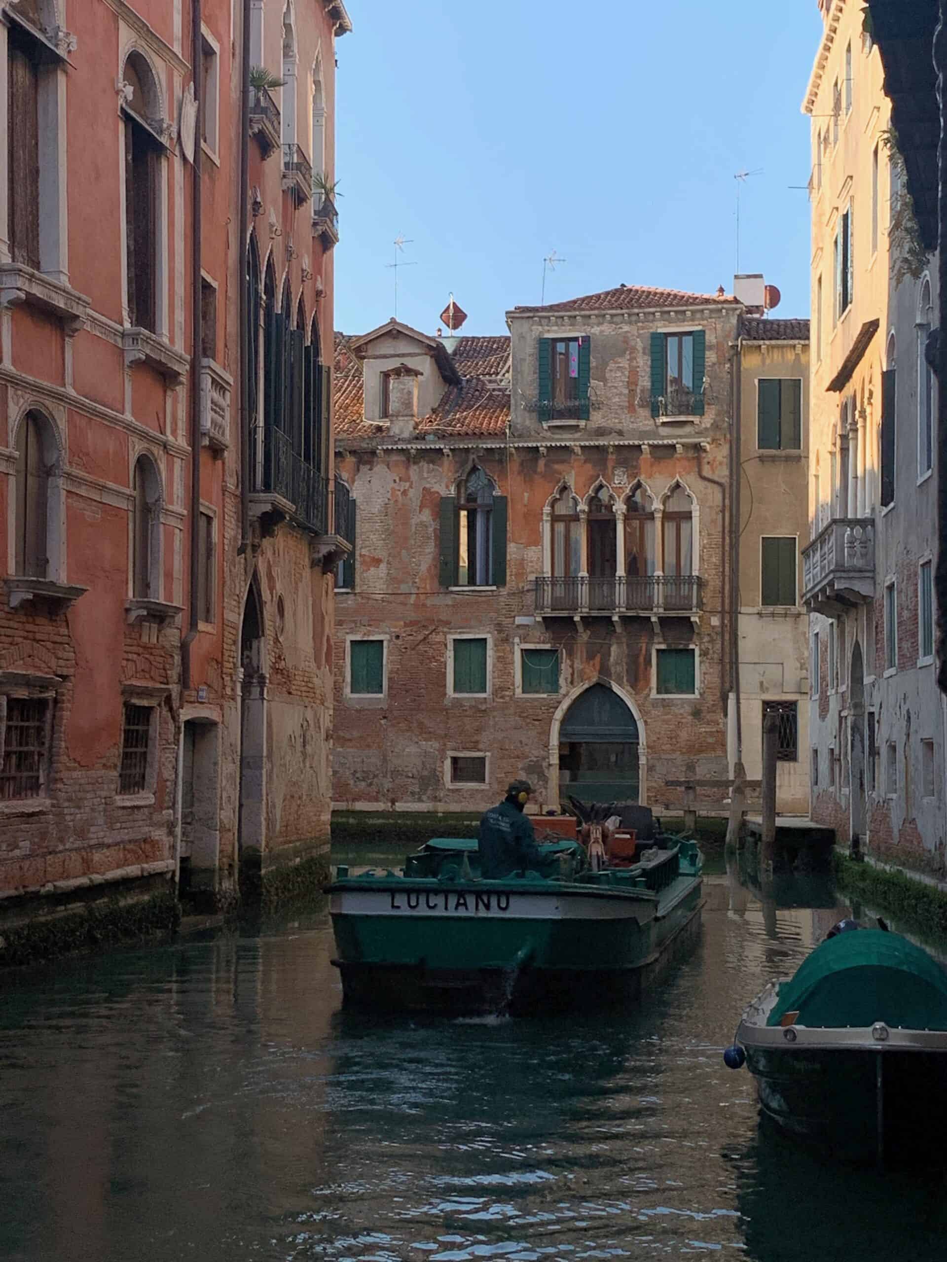 Canal en Venecia con casas tradicionales - Canal con edificios tradicionales venecianos reflejados en el agua.