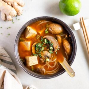 Vista superior de la sopa de tofu coreana y champiñones, enfatizando su sabor audaz y umami.