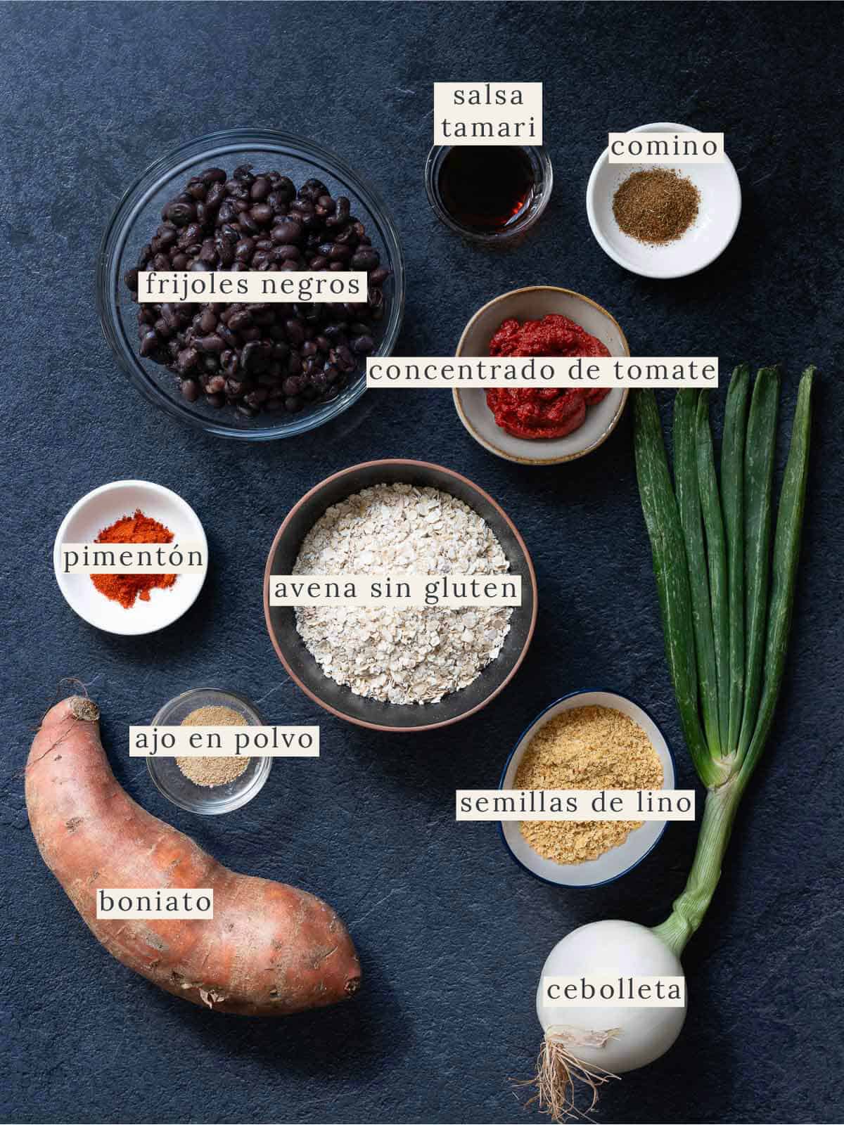 Ingredientes etiquetados para la receta de hamburguesas de frijoles negros, incluyendo frijoles, avena, batata y especias.