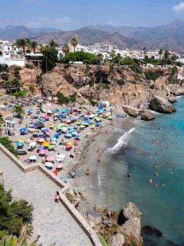 Playa de Calahonda llena de gente con sombrillas de colores.
La más accesible se encuentra justo debajo del Balcón de Europa, llamada Playa de Calahonda; solo necesitas bajar las escaleras junto a la vista panorámica y estarás allí.