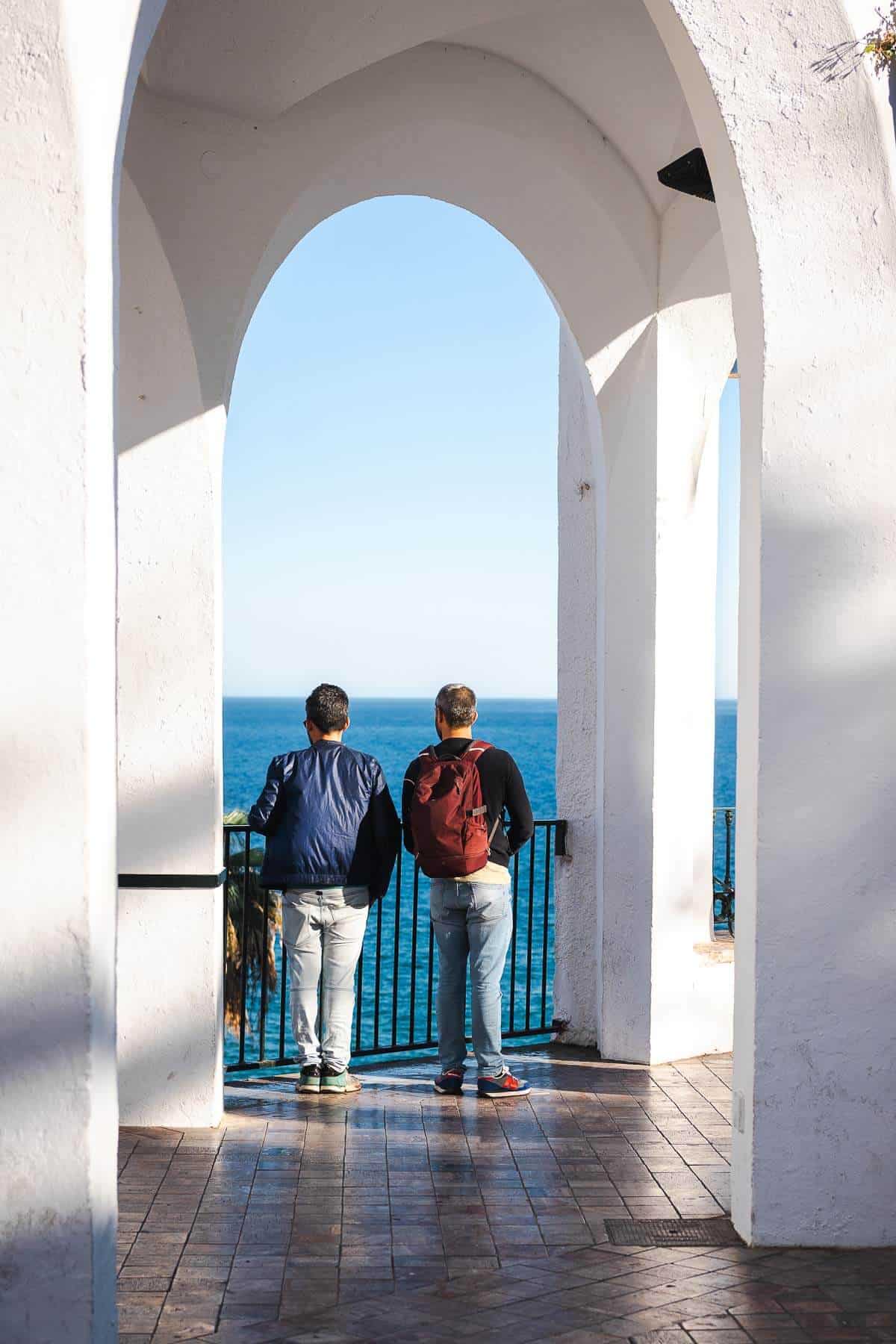 Dos chicos mirando el mar desde el Balcón de Europa en Nerja.