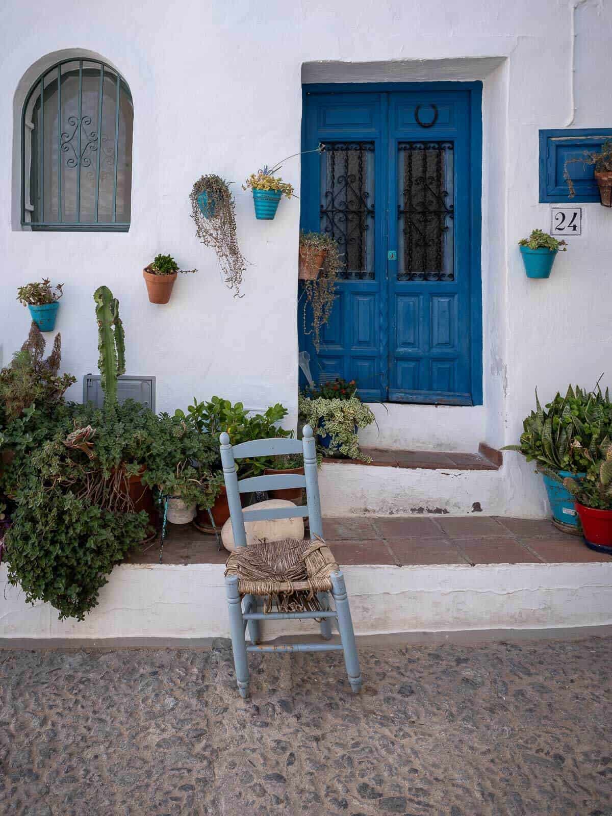 Una encantadora puerta con acentos azules y plantas en macetas en el pueblo de Frigiliana.