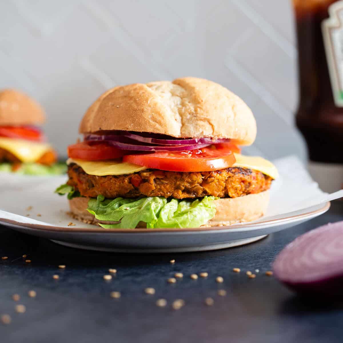 Hamburguesa de lentejas y avena estilo gourmet – Primer plano de una hamburguesa vegana con toppings frescos y pan, ideal para una comida plant-based.