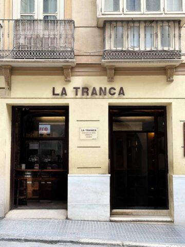 Bar La Tranca: Interior animado con barriles y clientes cantando junto a música vintage.